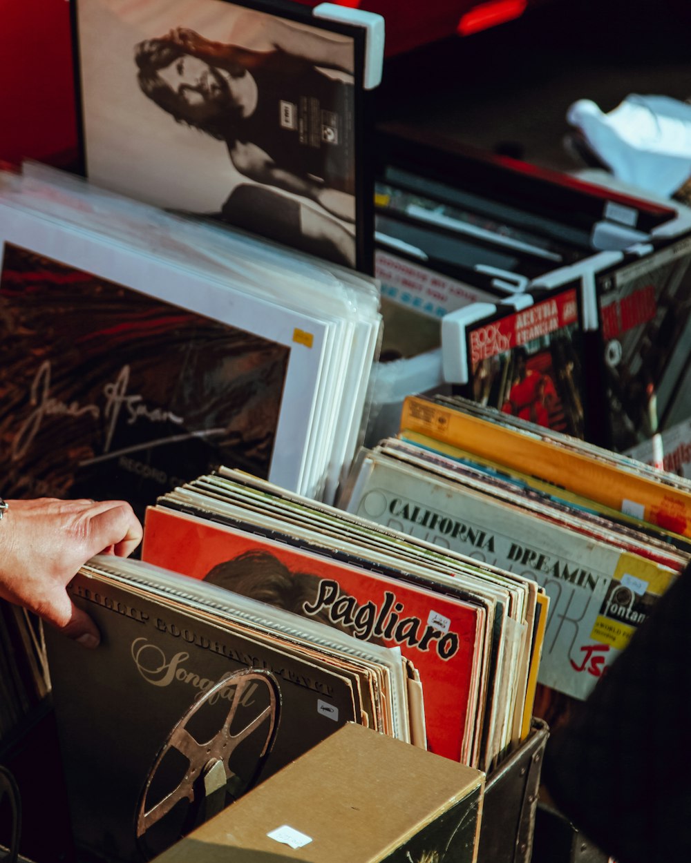 Vinyles dans un bac Une main feuillette des vinyles dans un bac
